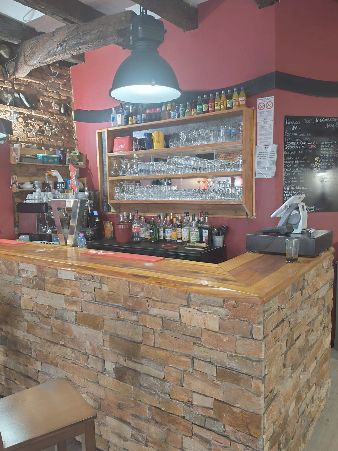 Le bar du Rendez-vous vu de la salle, mur rouge et poutres